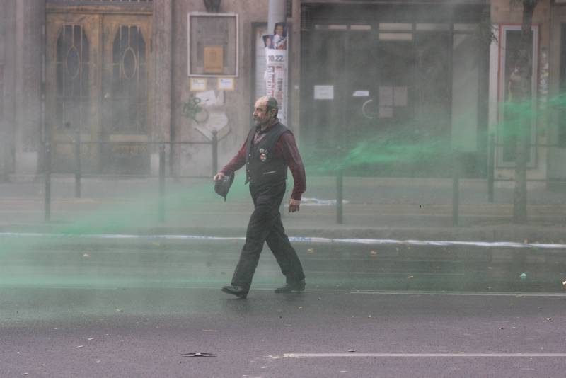 The same protester, dyed green by the water cannon